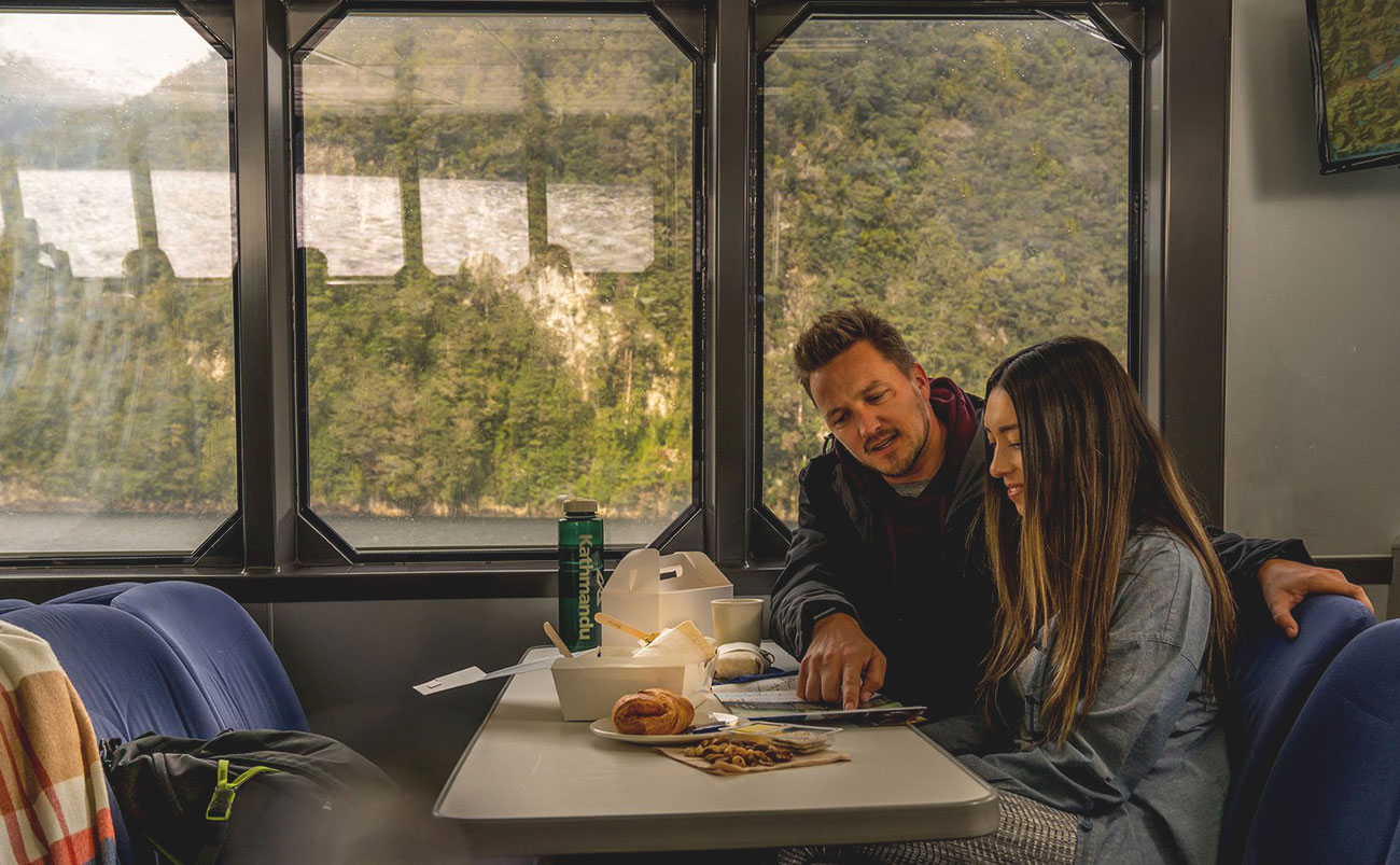 A hearty cooked breakfast being served on board the Doubtful Sound overnight cruise, with views of the fiord through the dining room windows