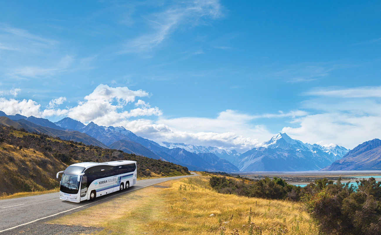 Passengers travelling on a Kirra Tours coach through New Zealand with scenic landscapes visible through the windows