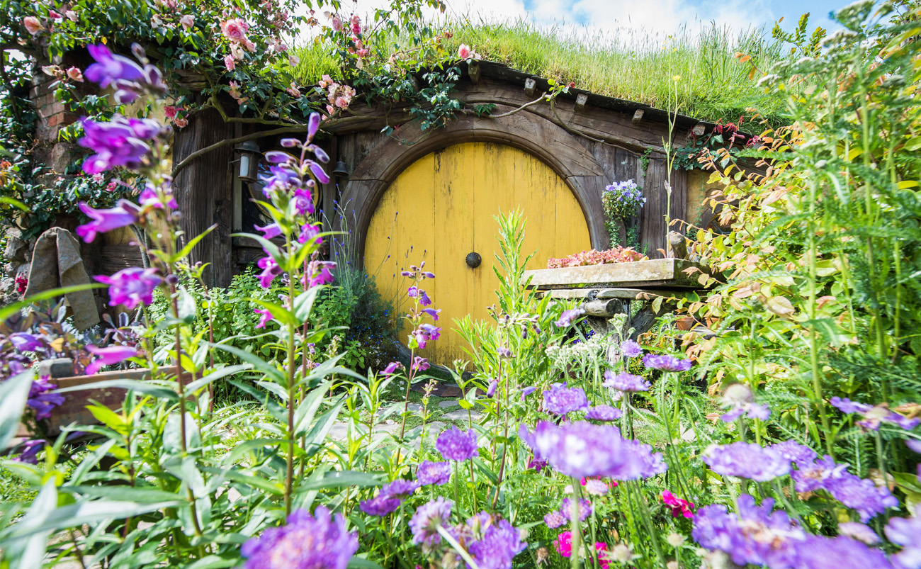 Hobbiton Movie Set in Matamata surrounded by spring flowers, fresh greenery and colourful Hobbit Holes in the Waikato, New Zealand