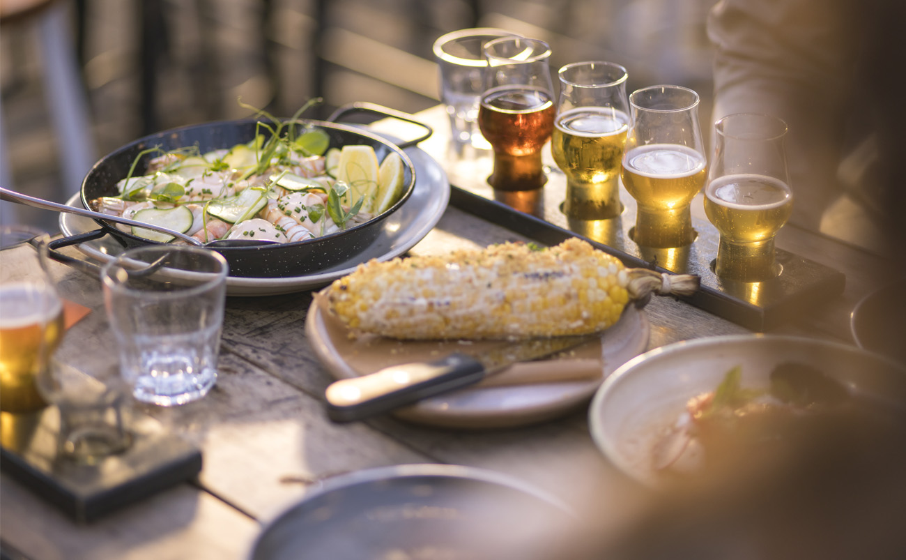 Outdoor dining scene on Auckland's waterfront with restaurants, city lights and harbour views